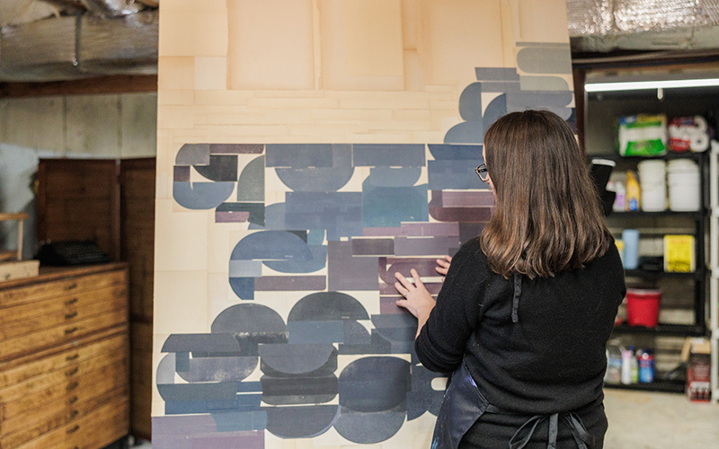 A woman in front of a large collage